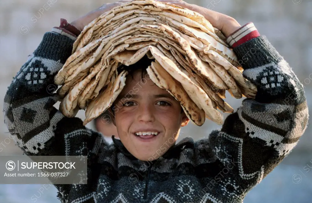 Boy wearing breads on his head, Maaloula christian village, Syria
