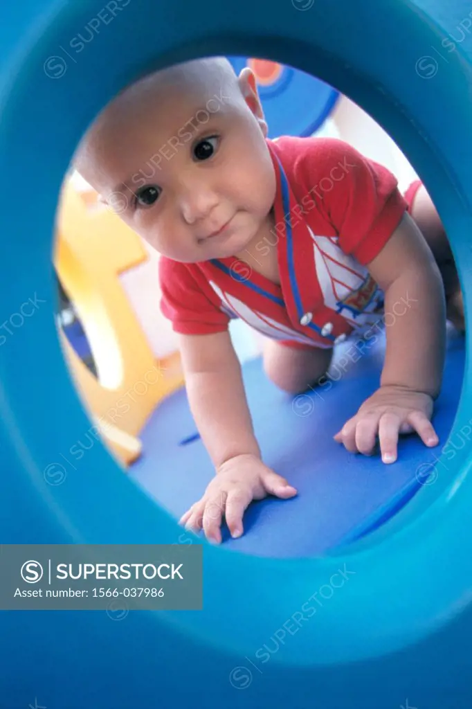 Infant boy playing on plastic playground