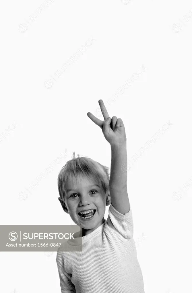 image of young boy making a peace sign with his fingers