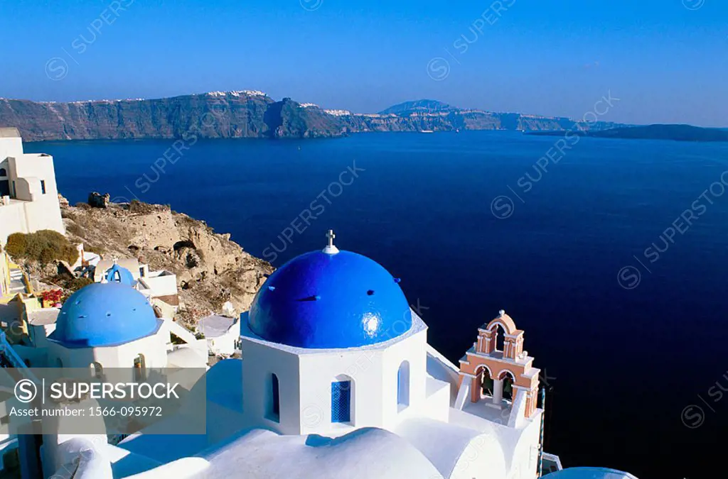 Greece, Cyclades Islands, Santorini. Oia village, White Churches with blue dome in front of the sea.