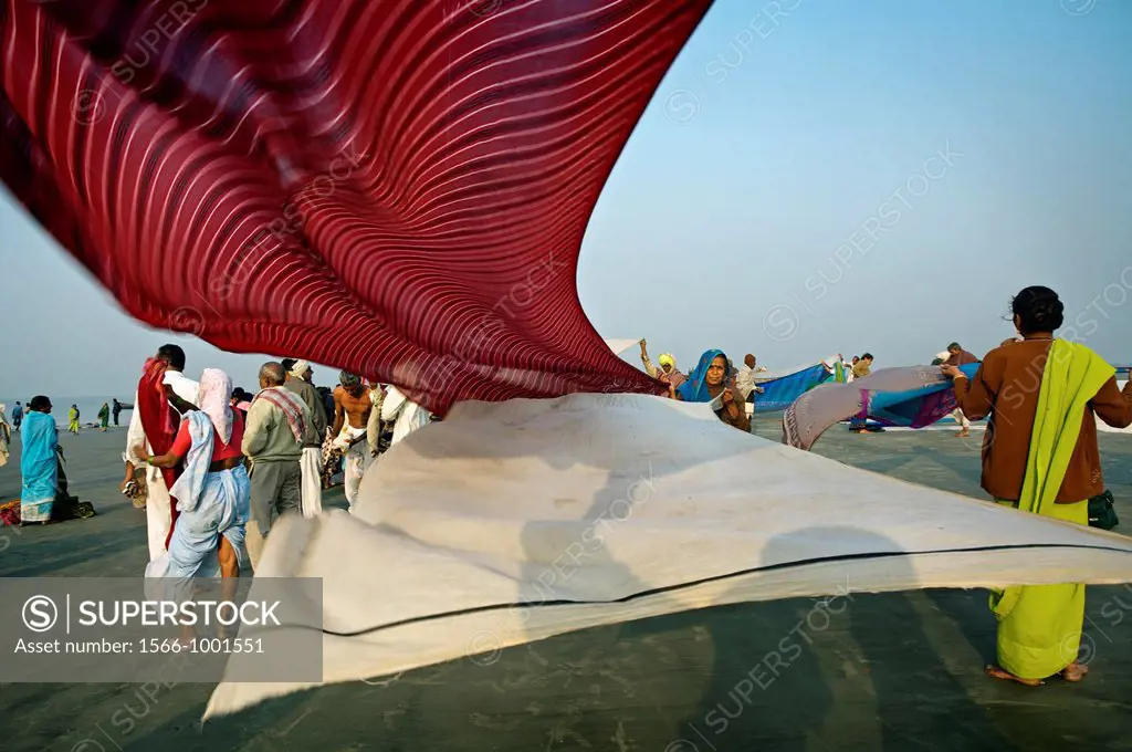 Pilgrims drying their clothes after bathing at the confluence of the river Ganges and the Bay of Bengal , Sagar Mela, India, Ganges River.