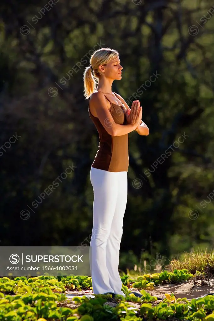 Attractive woman practices yoga at Makena, Maui, Hawaii