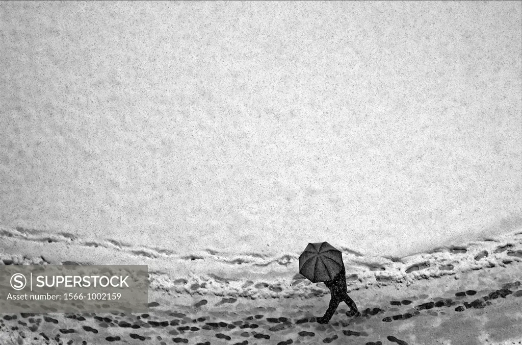 lonely man walking under umbrella in heavy snowfall, footprints in snow, Geneva, Switzerland, Europe, Europeans