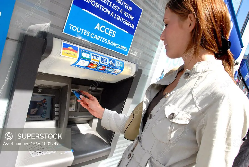 20 years old woman taking cash at a cash point