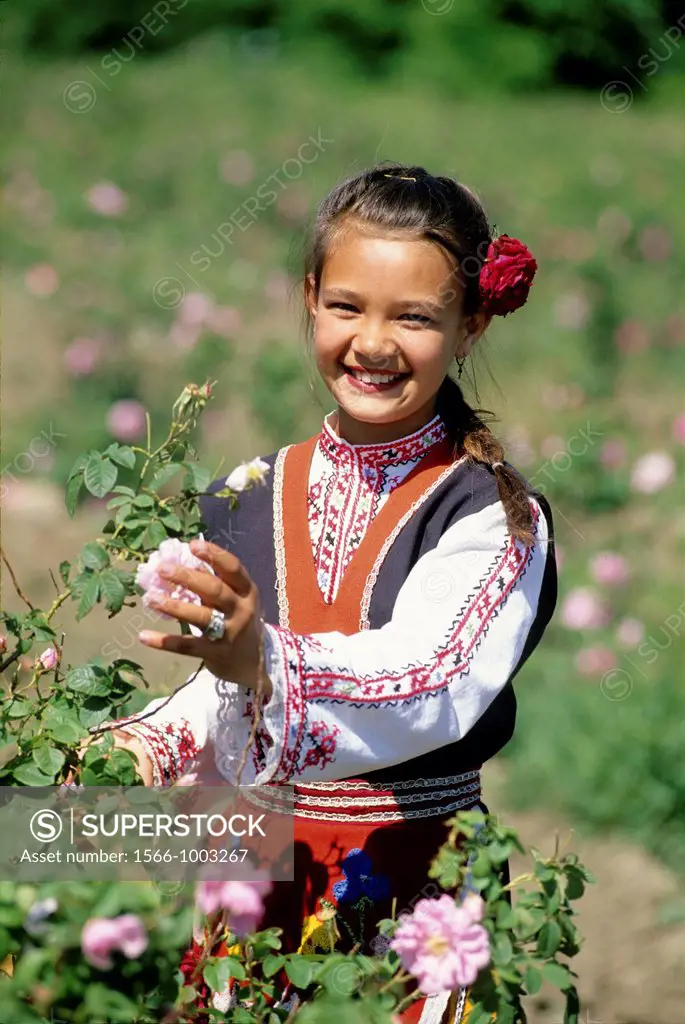 traditional dressed young girl in a rose garden during the Rose Festival in the Rose Valley, Kazanlak, Bulgaria, Europe