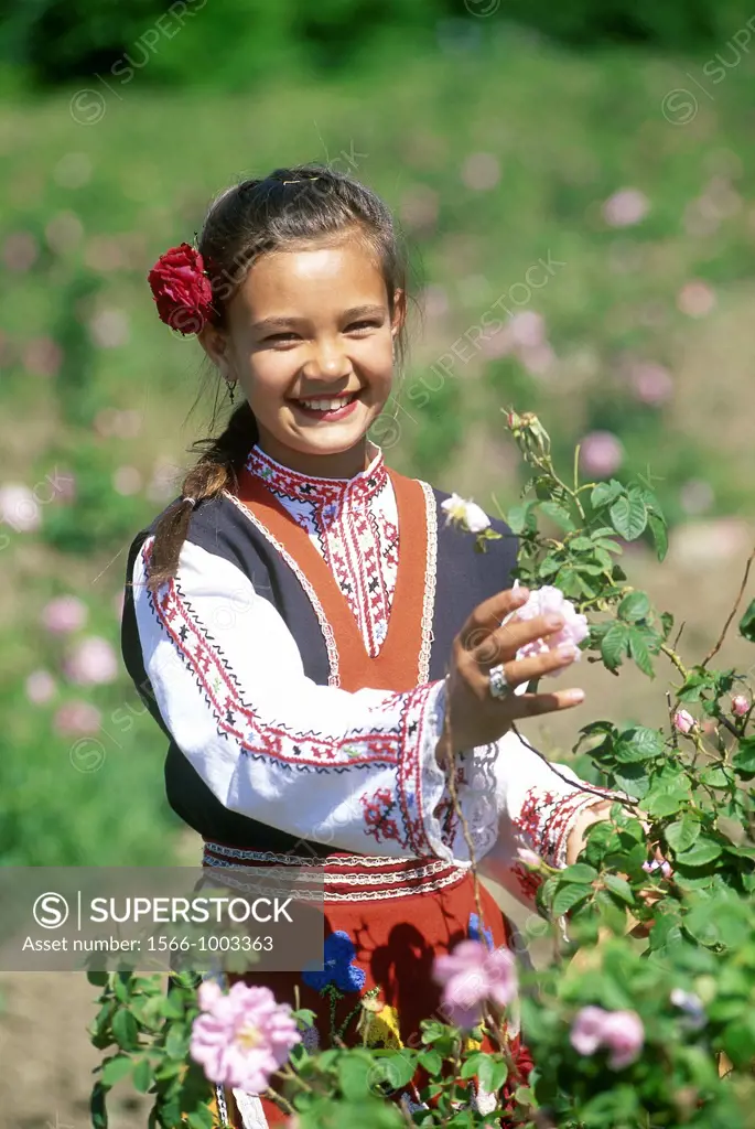 traditional dressed young girl in a rose garden during the Rose Festival in the Rose Valley, Kazanlak, Bulgaria, Europe