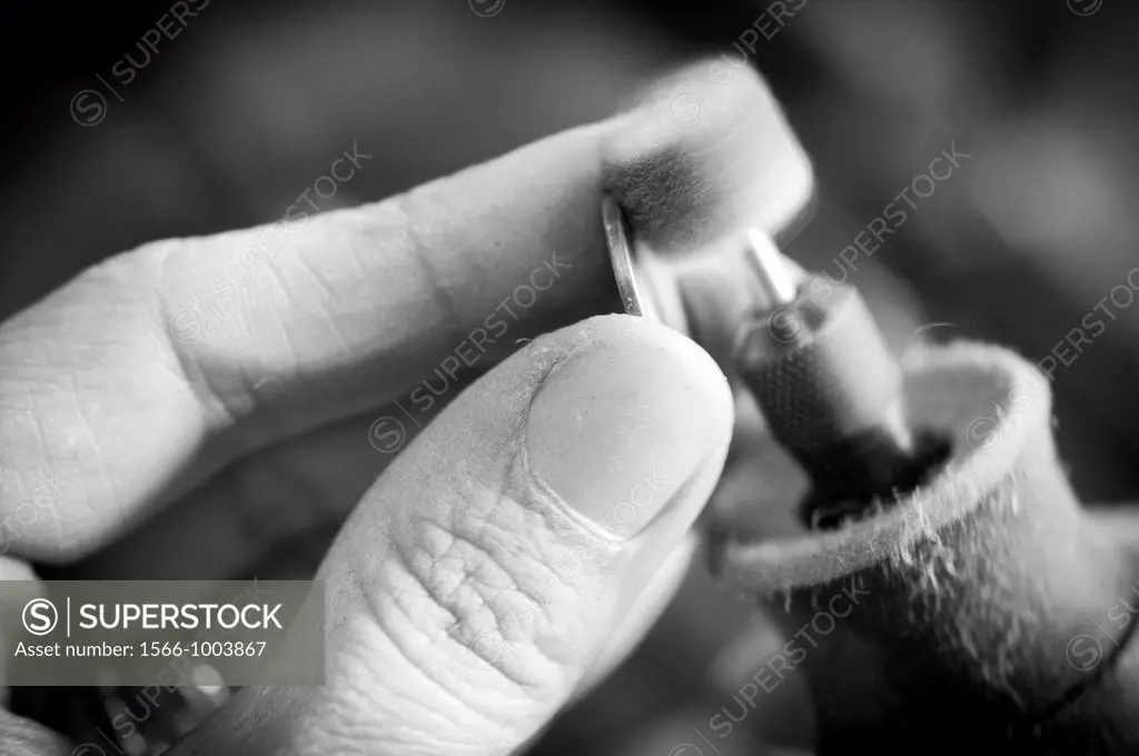 Jewelery maker polishing work  Close up of artisan hands at work