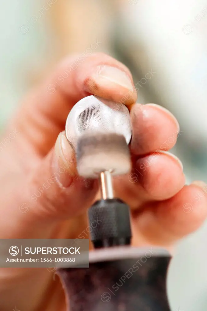 Jewelery maker polishing work  Close up of artisan hands at work
