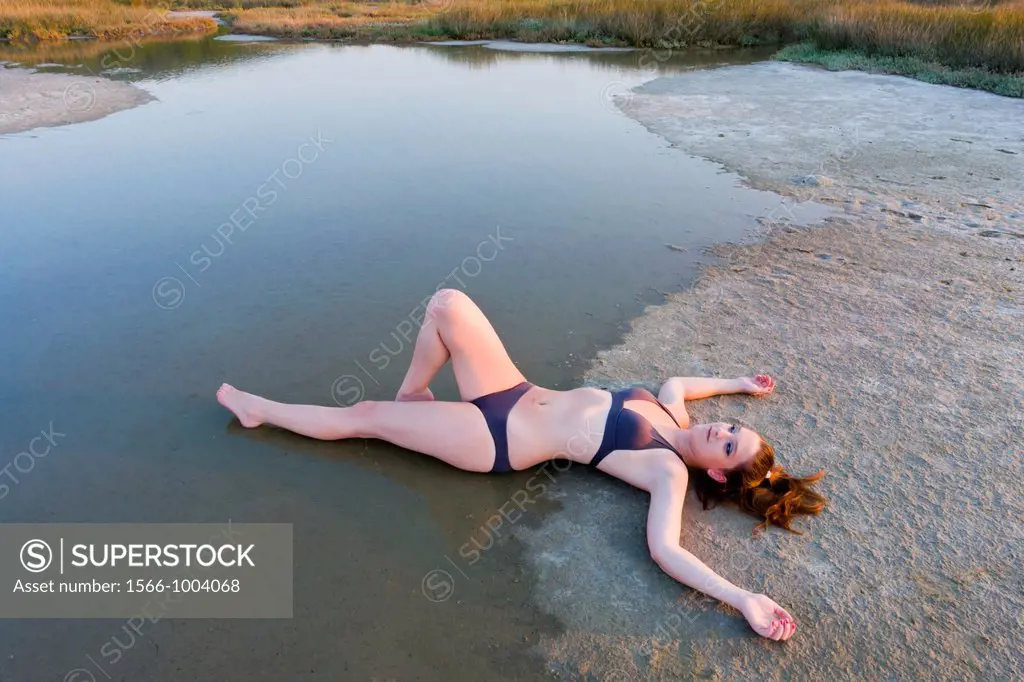 Young woman is stretching on a shoreline