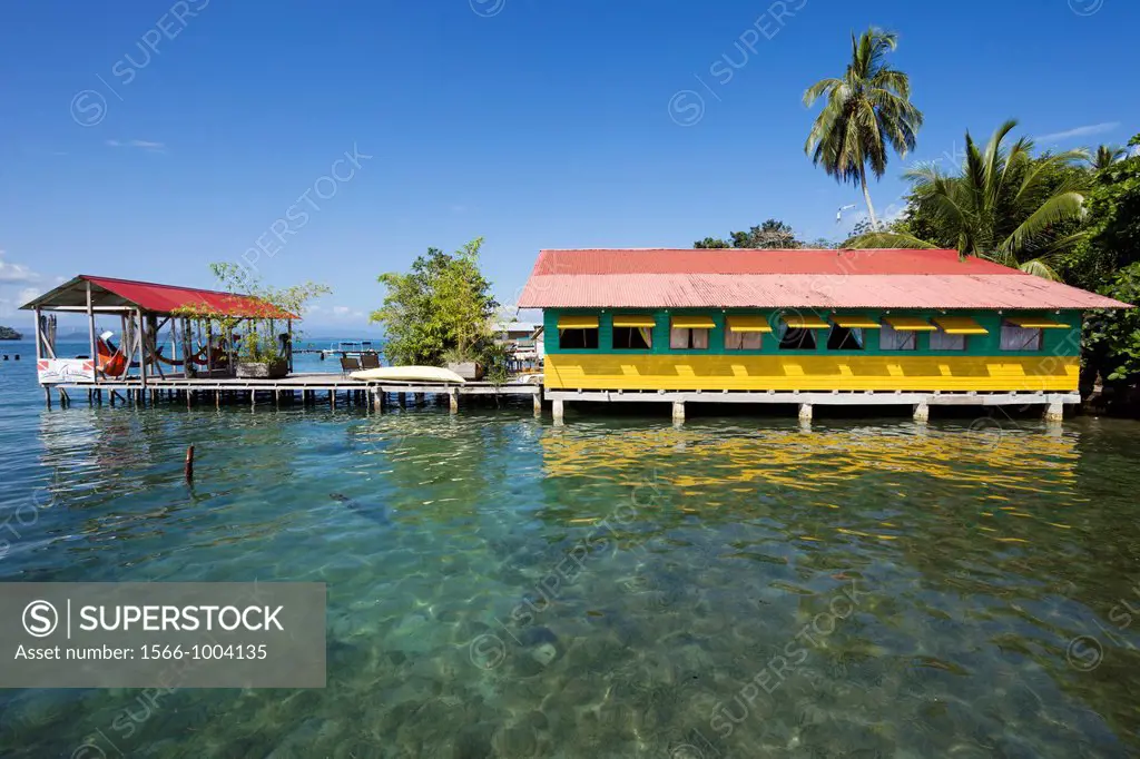 Brightly colored wooden houses sit over the sea in the historic town of Old Bank on Isla Bastimentos, Bocas del Toro, Panama