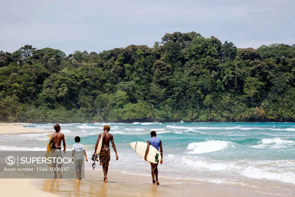 Surfers walking along the sea at Wizard Beach First Beach on Isla Bastimentos, Bocas del Toro, Panama