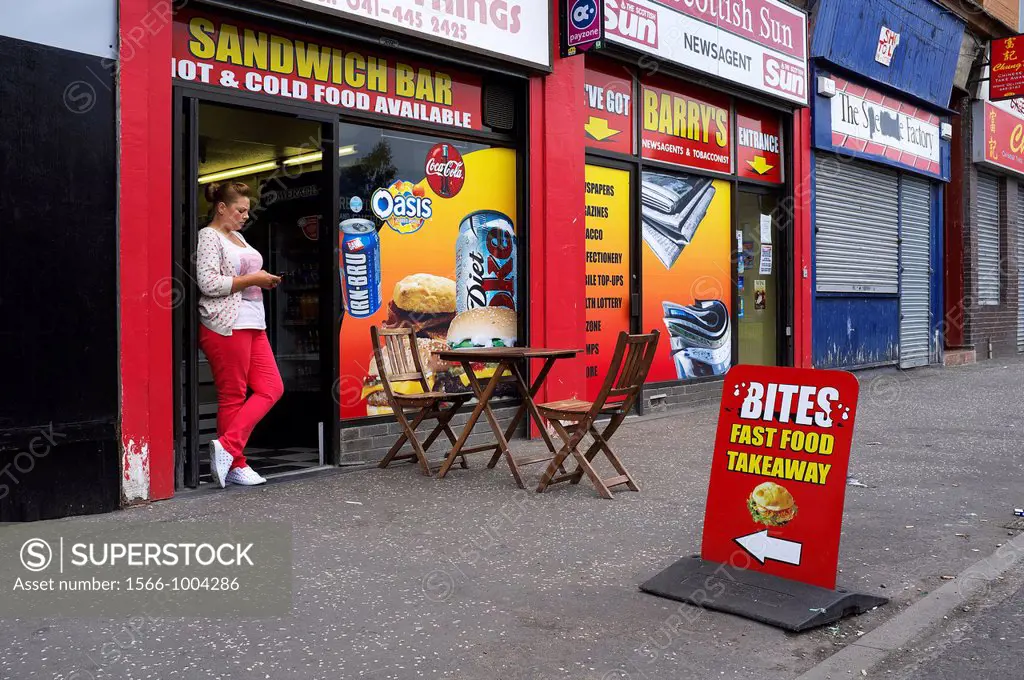 Proprietor of a small sandwich bar and carryout coffee shop with a small pavement table, Govan Road, Govan, Glasgow, Scotland