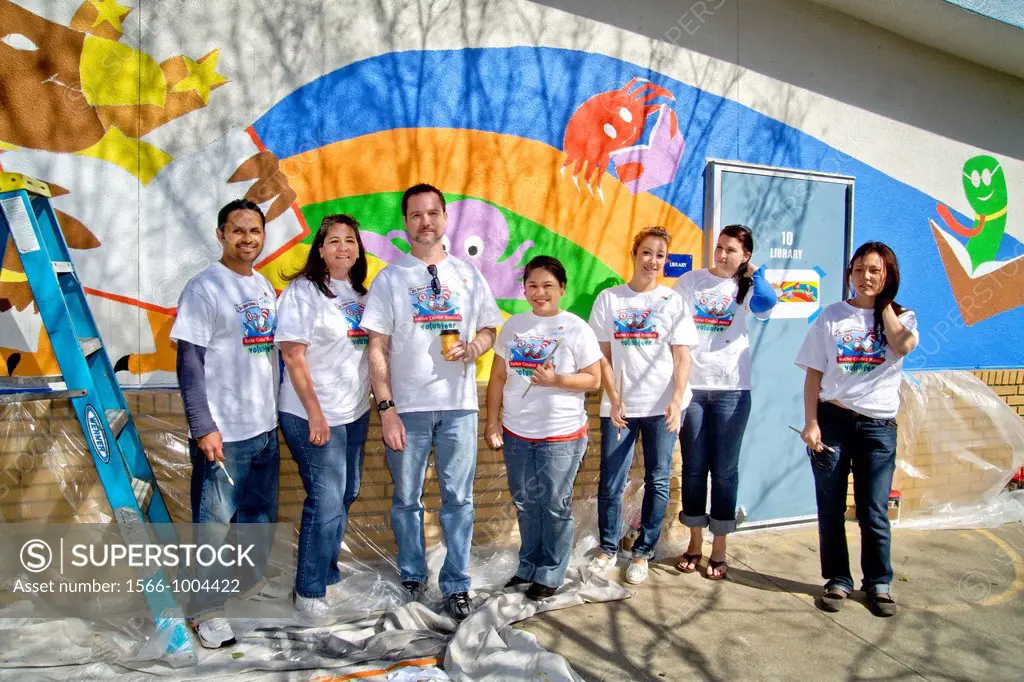 Volunteer painters pose before a just-repainted library wall at an outdoor ´Dr  Seuss Annual Literacy Fair´ at a middle school in Westminster, CA