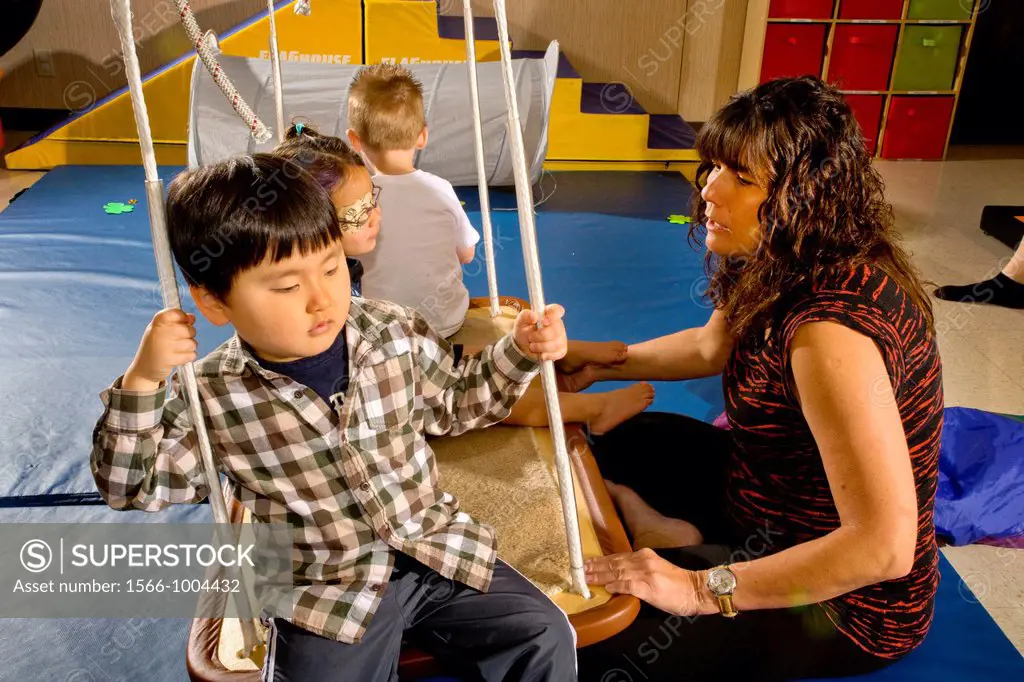 Blind and vision-impaired children ride a swing to improve their balance and body awareness in a sensory motor group at the Blind Children´s Learning ...