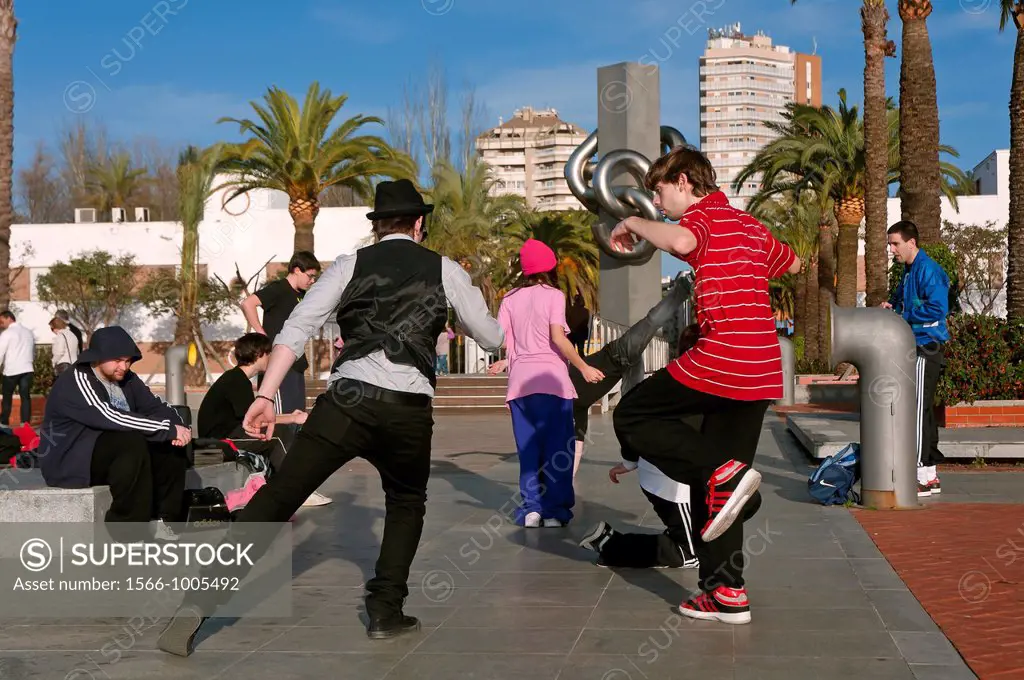 Young people dancing next to the sculpture The Knot by Jose Noja, Huelva, Spain,