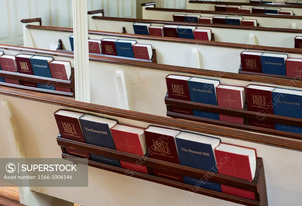 Church pews with prayer books and hymnals.