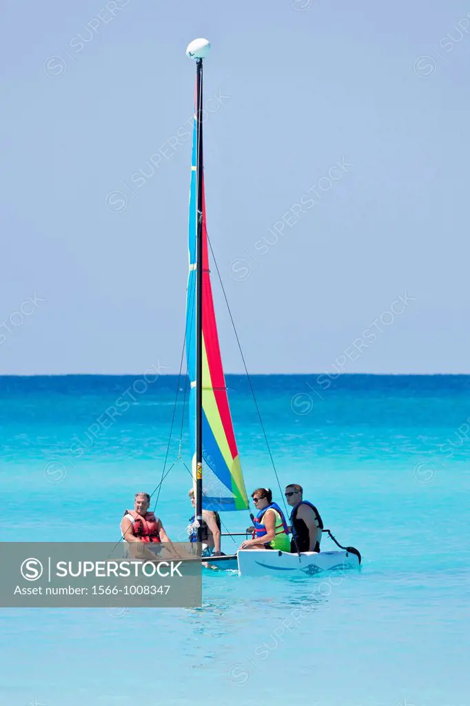 Four people on Hobie Cat catamaran in waters of Half Moon Cay, Bahamas