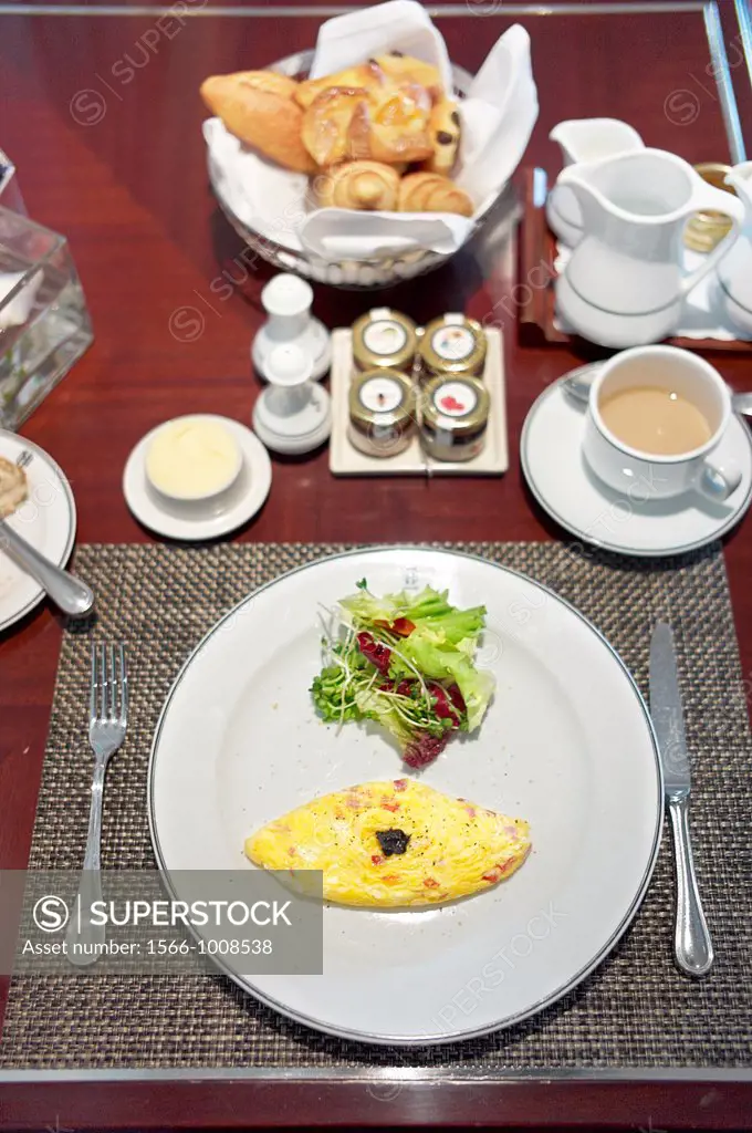 A complimentary Western styled breakfast consisting of a omelette, small side salad, croissants, and coffee
