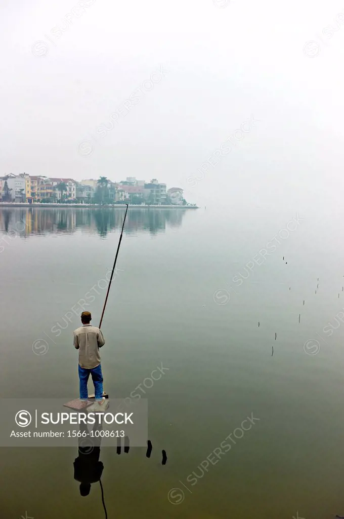A lone fisherman at at West Lake in Hanoi, Vietnam