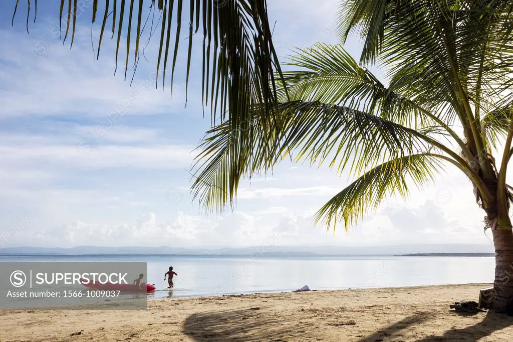 Two boys playing in the ocean at Starfish beach on Isla Colon, Bocas del Toro, Panama