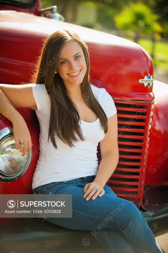 Highschool senior, female caucasian, 17 years old, posing sitting on bumber of oldtimer truck