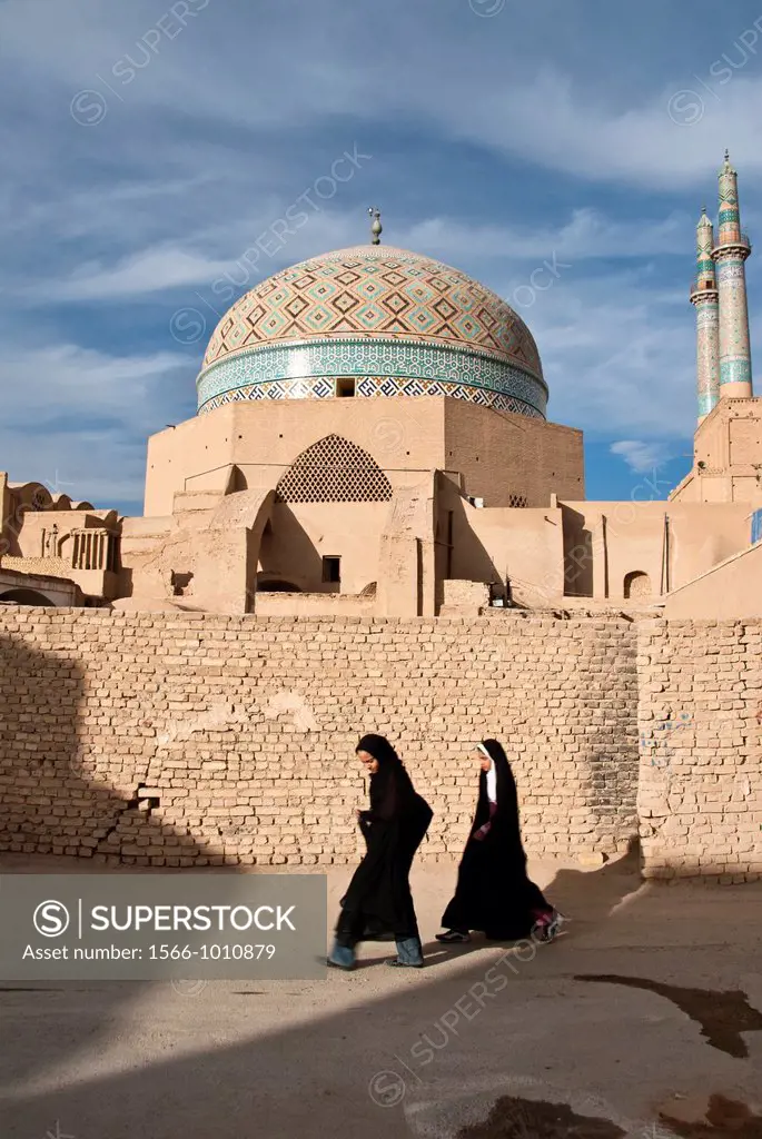 Children wearing Hijab walking in front of the Jameh Mosque of Yazd, Iran