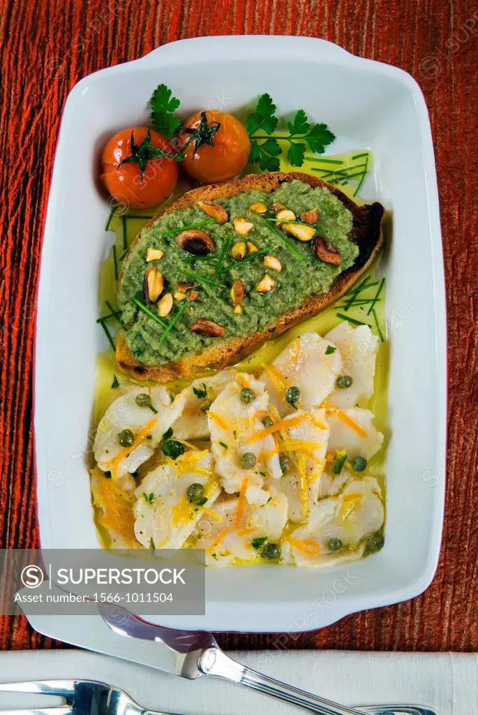 Cod carpaccio carpaccio is a dish of raw meat or fish with tomatoes and crostino with cream of artichoke and pistachios