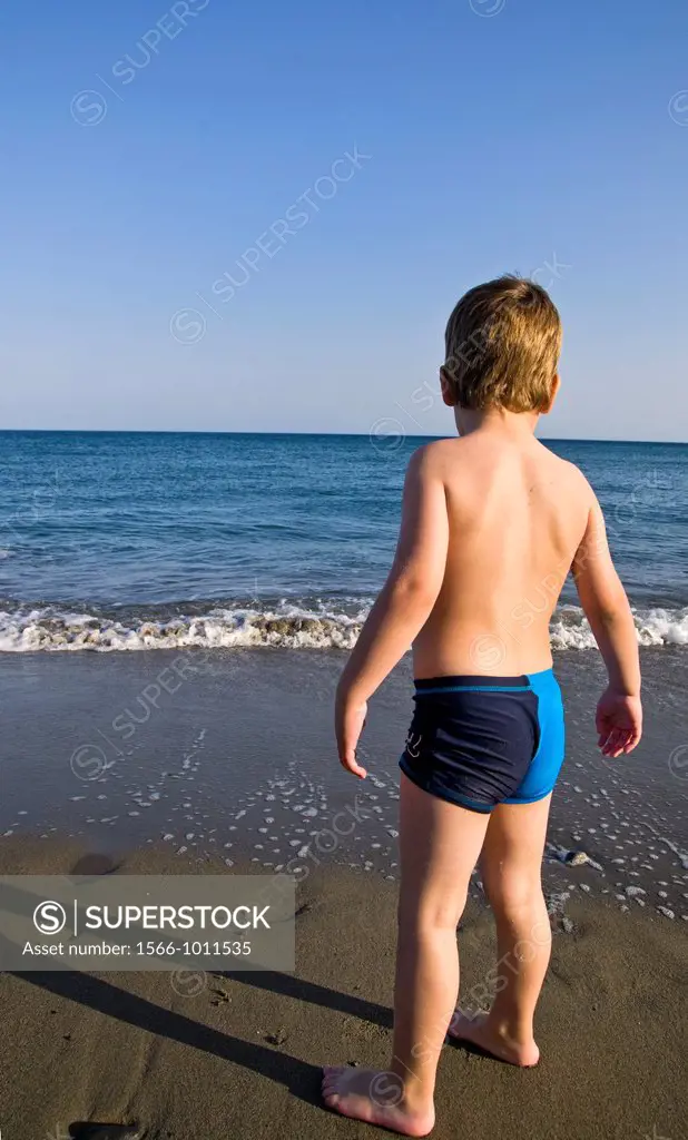 Blond child watching the waves, Crete, Greece