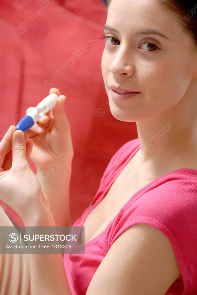 Home pregnancy testing  Young woman looking at the result of a home pregnancy test