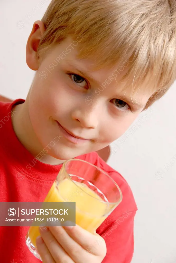 Young boy drinking orange juice