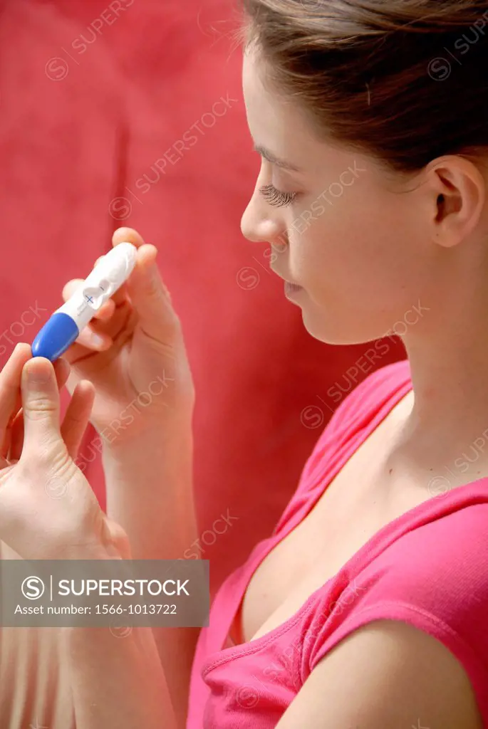 Home pregnancy testing  Young woman looking at the result of a home pregnancy test