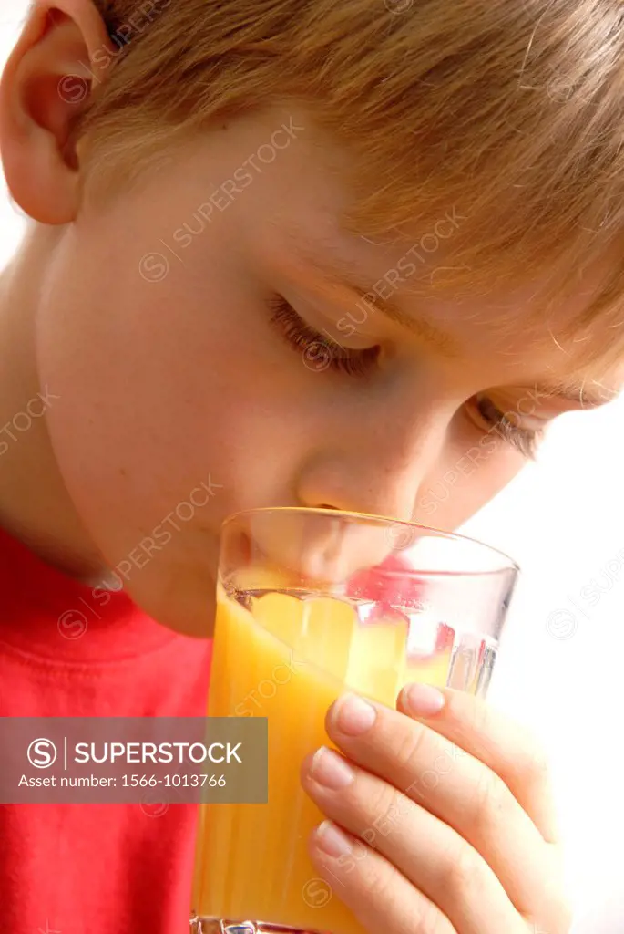 Young boy drinking orange juice
