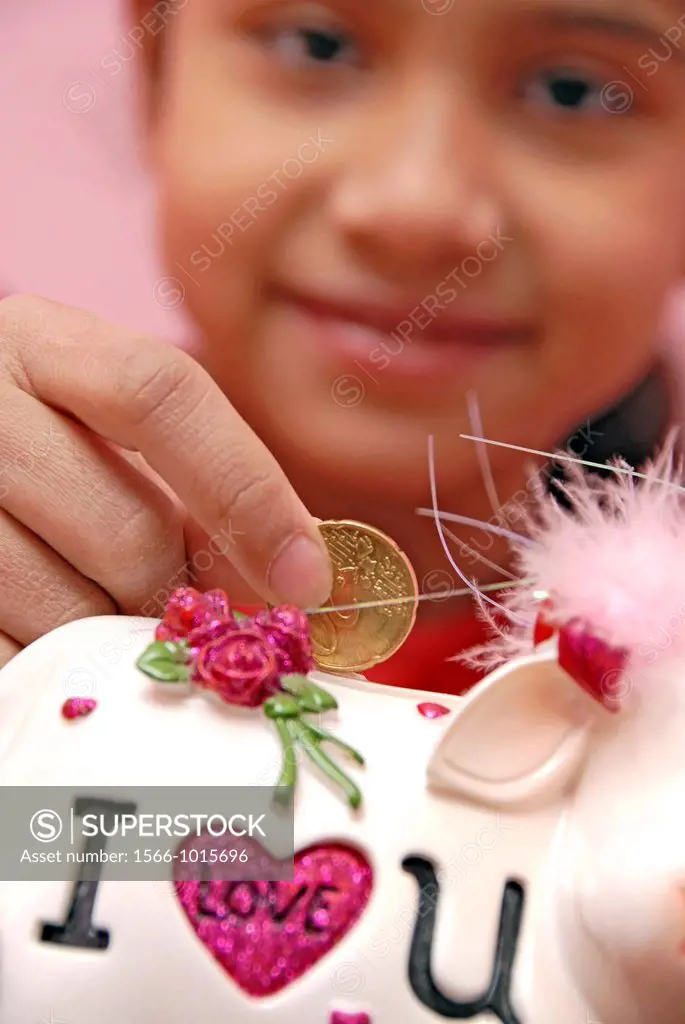 12 years old girl inserting coin in a money box