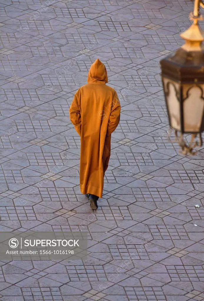 a hooded figure in the ancient medina in Marrakech, Morocco