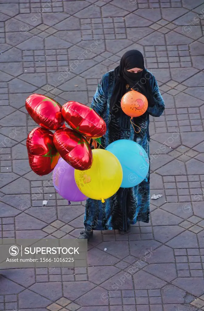 woman in burqa selling balloons in Marrakech, Morocco