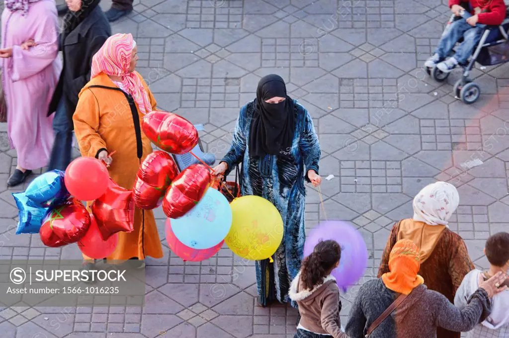 woman in burqa selling balloons in Marrakech, Morocco
