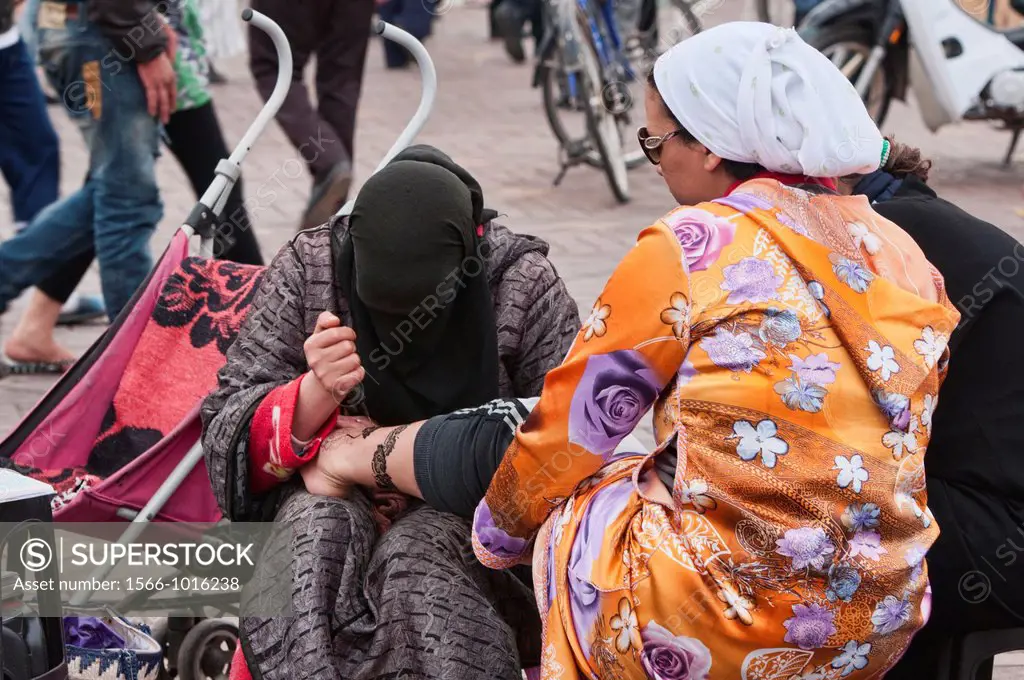 woman in burqa giving henna tattoos in Marrakech, Morocco