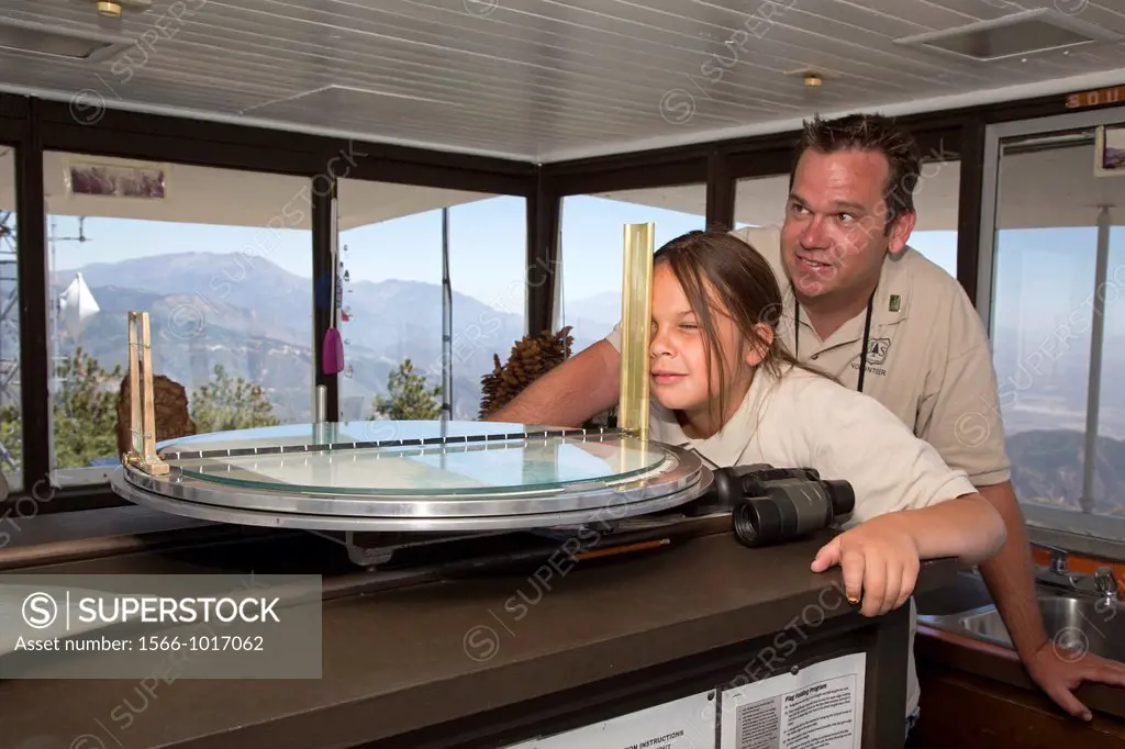 Twin Peaks, California - U S  Forest Service volunteer at the Strawberry Peak fire lookout tower, teaches his daughter, 10, how to determine the locat...