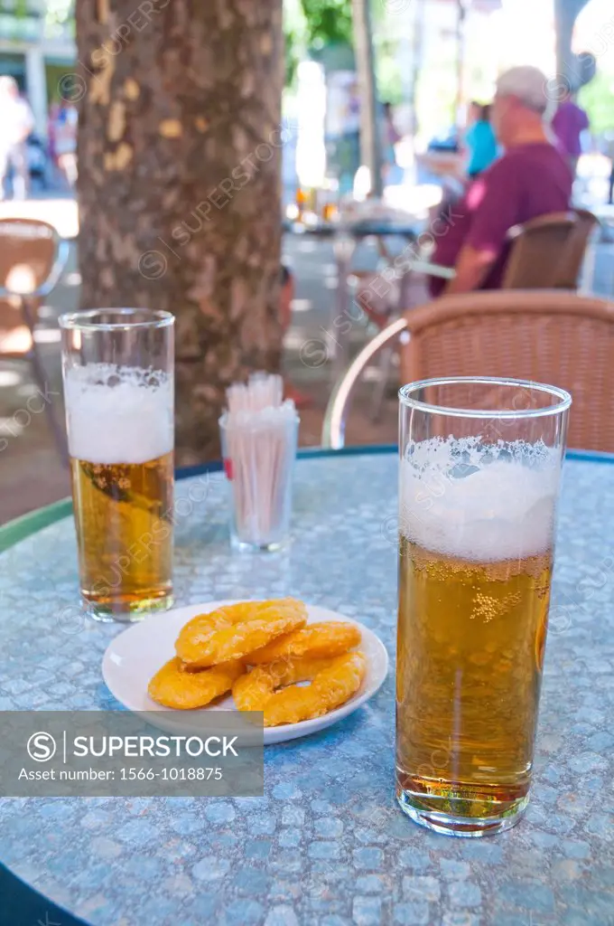 Spanish aperitif: two glasses of beer and fried squid tapa