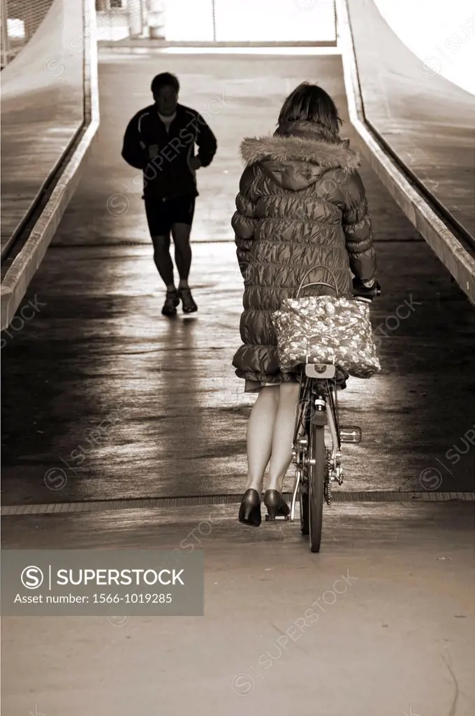 jogging man and a woman on a bicycle, under the Mt Blanc bridge, Geneva, Switzerland
