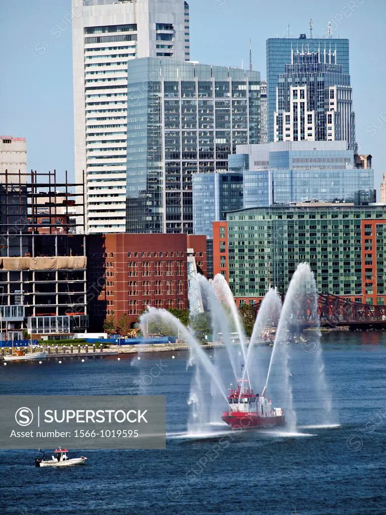 A fireboat displayes waterspouts in the Boston Harbor  Downtown Boston is beyond