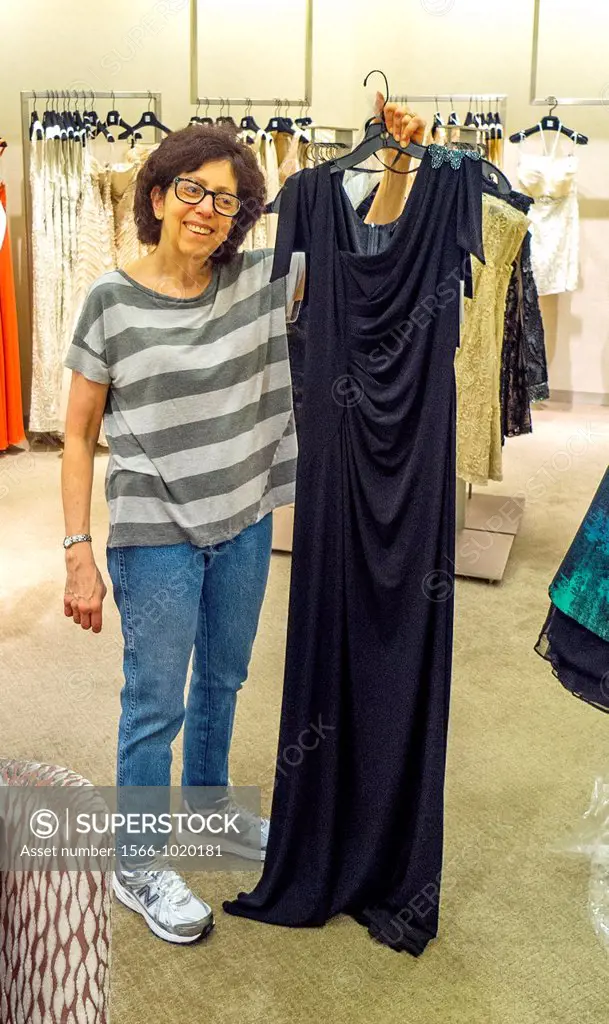 At Saks Fifth Avenue specialty store in New York, a happy mother buys a gown to wear at her daughter´s wedding