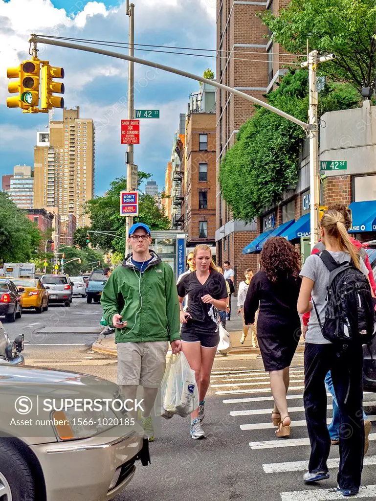 Pedestrians and a jogger share a crosswalk on West 42nd Street in midtown Manhattan, New York City