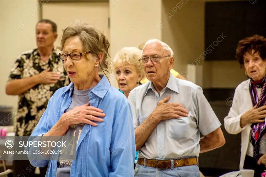 Senior citizens recite the Pledge of Allegiance before lunch at a senior center in Tustin, CA