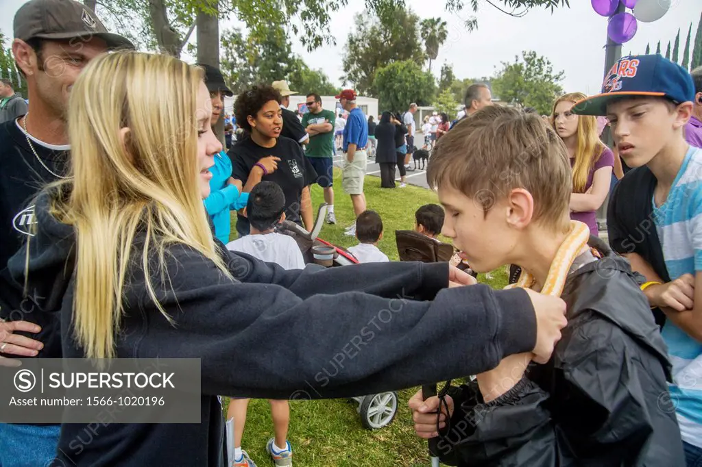 A girl puts a snake around the neck of blind boy to give a tactile experience at a fund raising event for children with vision problems in Santa Ana, ...