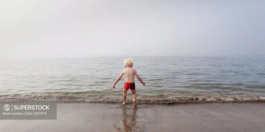 Young boy testing the cold waters, Akranes, Iceland