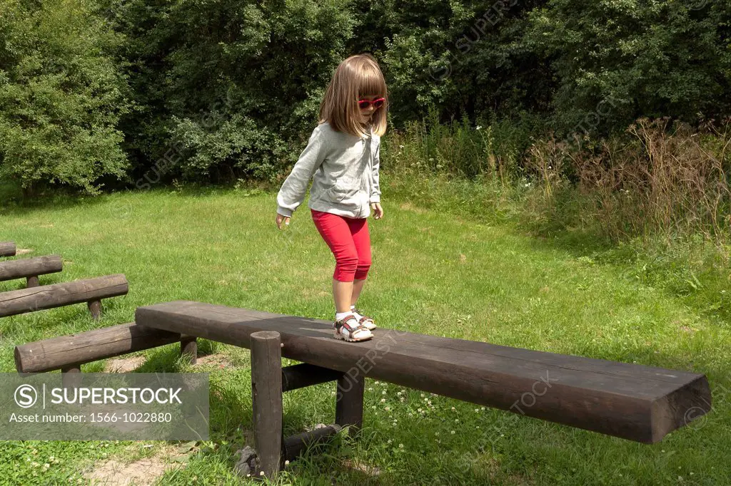 Girl walking on balance beam