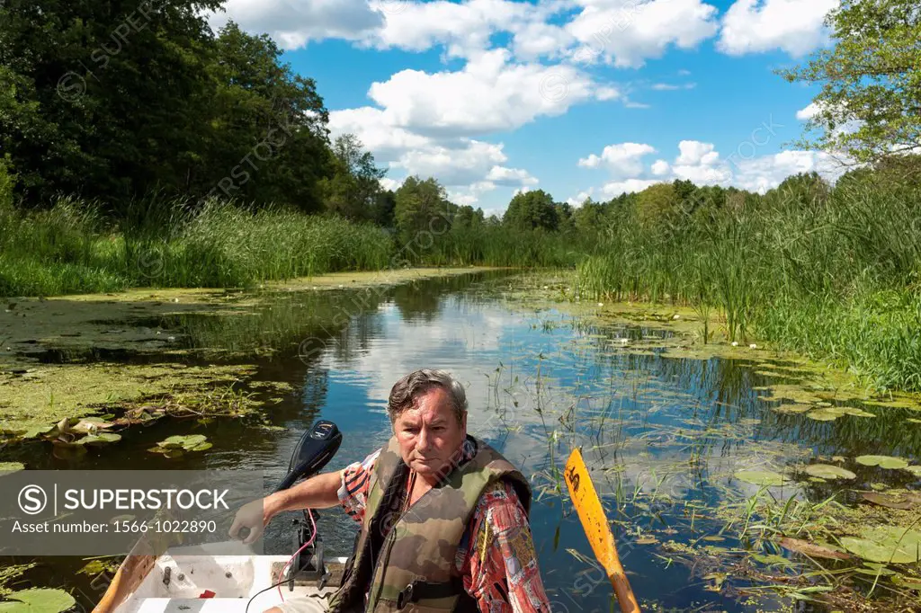 Man in fishing boat on Narew river, Poland