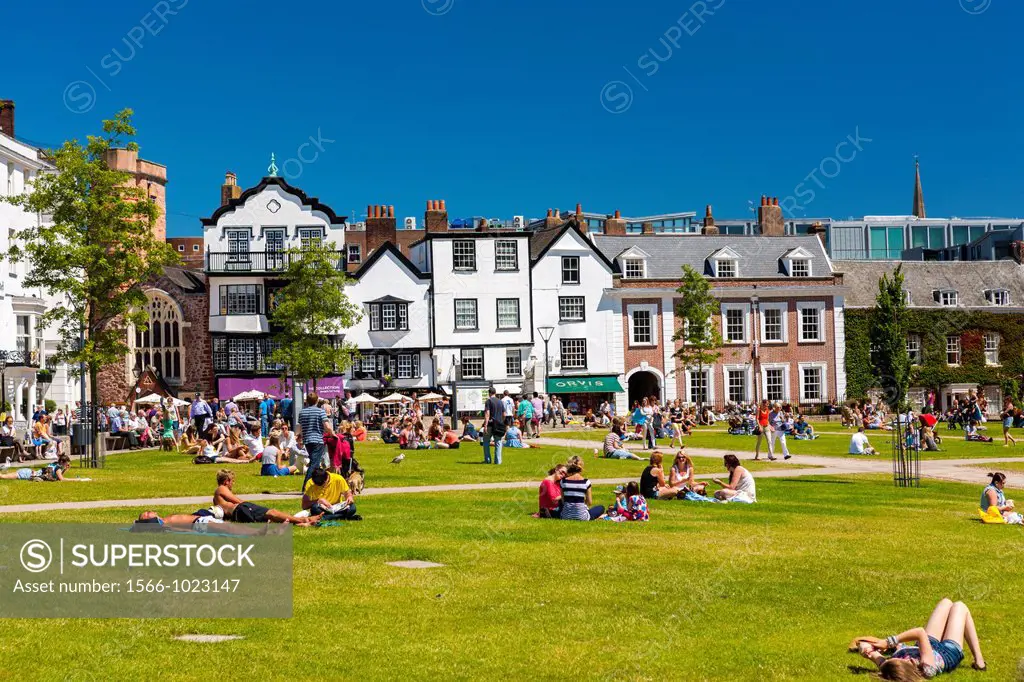 People relaxing on grass at Cathedral Close, Exeter, Devon, England