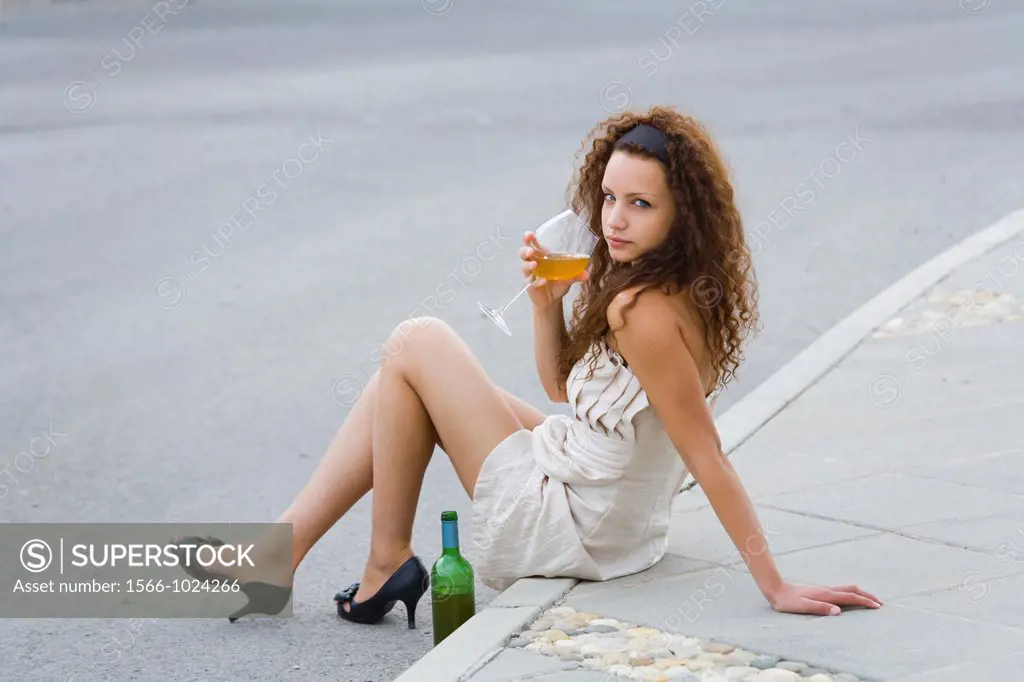 Fanciful girl at the edge of a roadway with a bottle